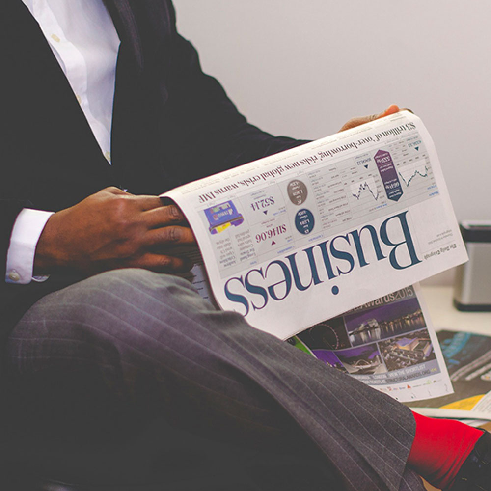 A business man reads the business section of a newspaper