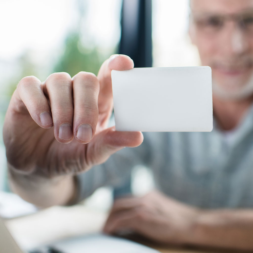 Business man holds up a business card