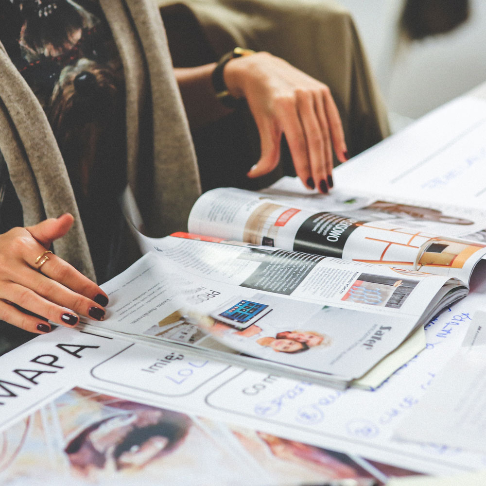 A woman leafs through a magazine, noticing the ads