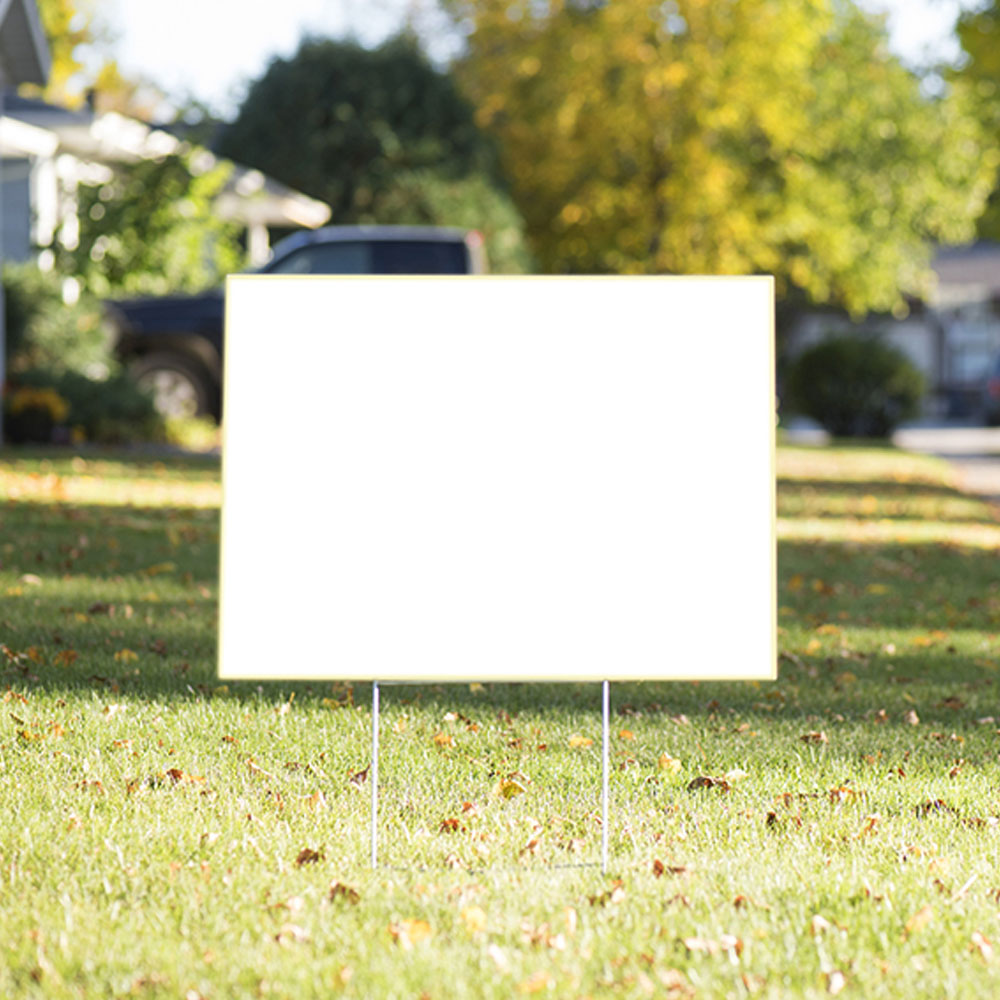 A blank yard sign posted on a lawn.